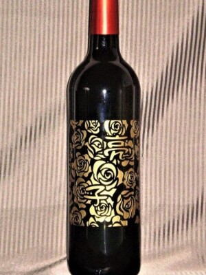 記念品に奇抜な持込みアイデアで<br>
バラの花いっぱいの背景に名前<br>
を入れたボルドーの赤ワイン彫刻<br>